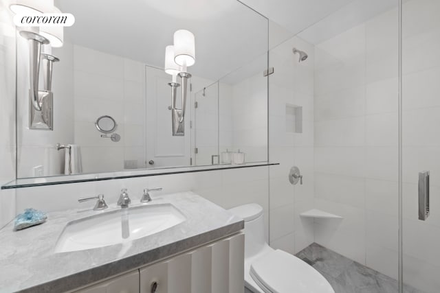 bathroom with vanity, a shower with door, and toilet