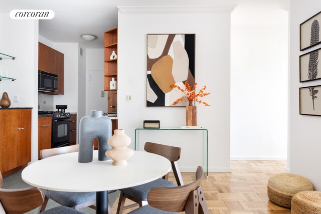 dining area featuring crown molding and light parquet floors