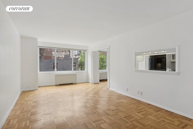 empty room featuring radiator and light parquet flooring