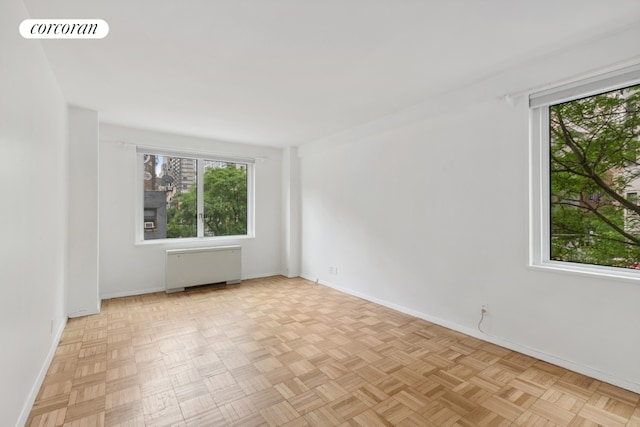 spare room featuring light parquet floors and radiator heating unit