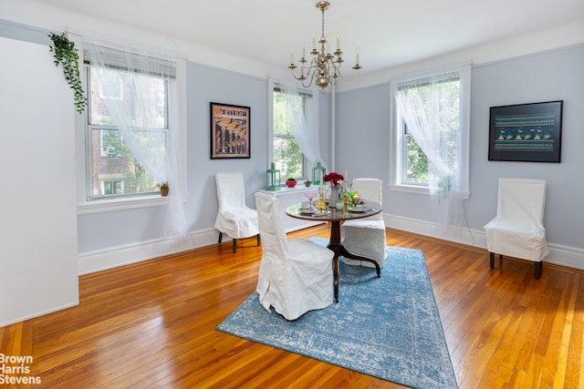 dining room with hardwood / wood-style flooring, plenty of natural light, and a chandelier