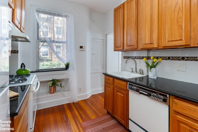 kitchen with dark hardwood / wood-style flooring, sink, white appliances, and plenty of natural light