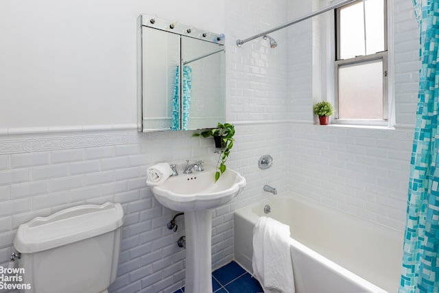 bathroom featuring tile walls, shower / tub combo, and toilet