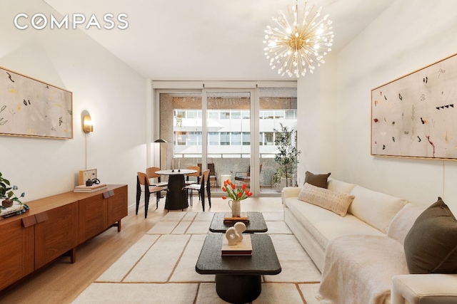 living room with light wood-type flooring and an inviting chandelier