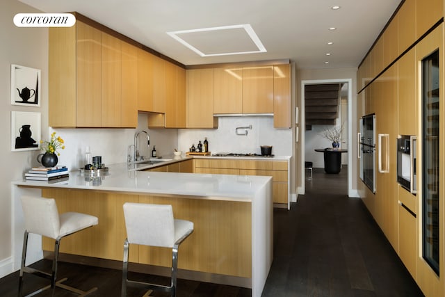 35 Hudson Yards Unit 7302, New York City, NY 10001 - kitchen with a sink, a peninsula, gas cooktop, light countertops, and a kitchen bar