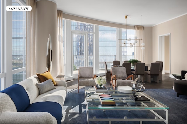 living room featuring a wealth of natural light, a notable chandelier, and wood finished floors