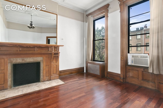 unfurnished living room featuring crown molding, a premium fireplace, wood finished floors, cooling unit, and baseboards