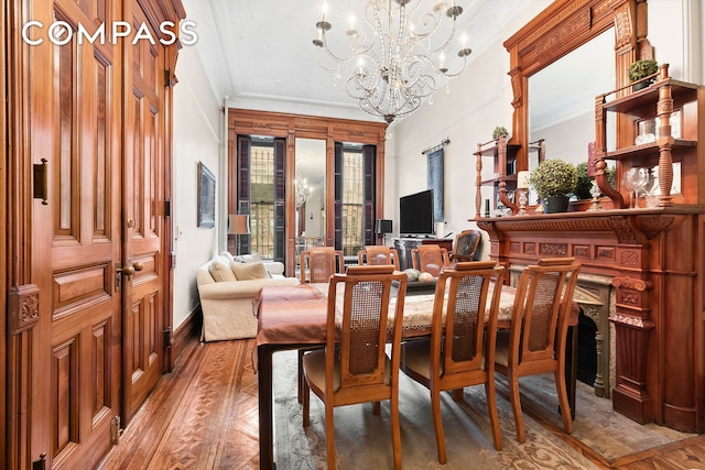 dining space featuring crown molding, an inviting chandelier, and light wood-style floors