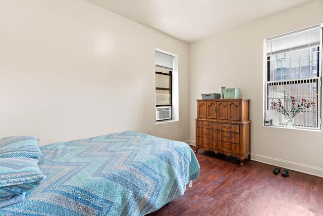 bedroom featuring cooling unit, wood finished floors, and baseboards