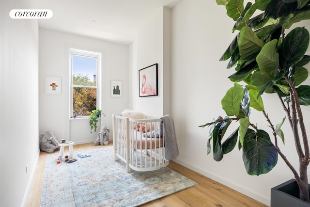 bedroom featuring a nursery area and hardwood / wood-style floors