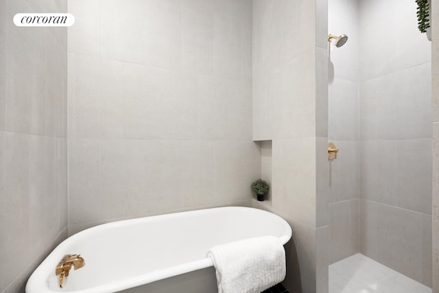 bathroom featuring a bathtub and tile walls