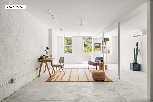 living area with concrete flooring and a wall mounted air conditioner