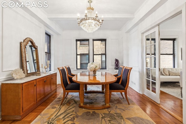 dining space featuring a notable chandelier, plenty of natural light, ornamental molding, and light hardwood / wood-style floors