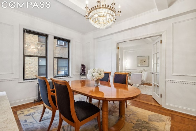 dining area with crown molding, a chandelier, and hardwood / wood-style floors