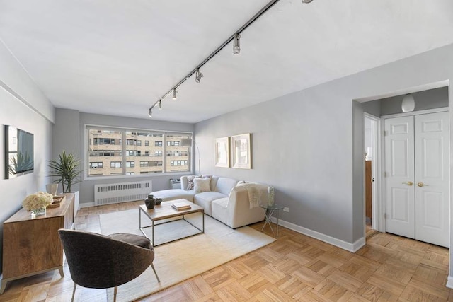 living room with light parquet floors, rail lighting, and radiator heating unit