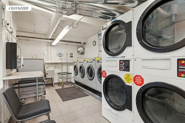 laundry area with light tile patterned flooring, stacked washer and dryer, and washing machine and dryer