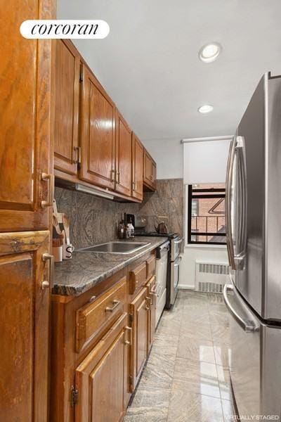 kitchen featuring stainless steel refrigerator, radiator, and tasteful backsplash