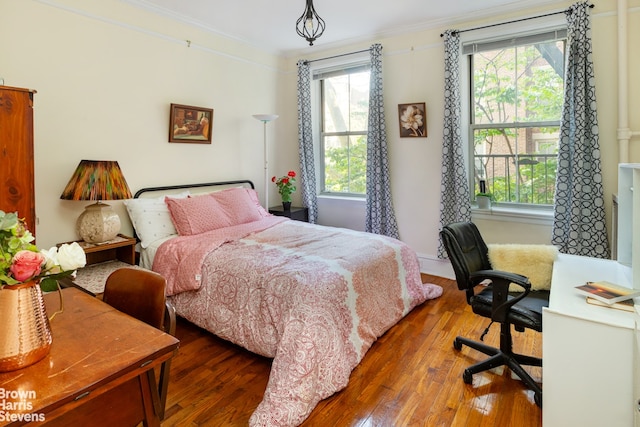 bedroom with multiple windows, dark wood finished floors, and crown molding