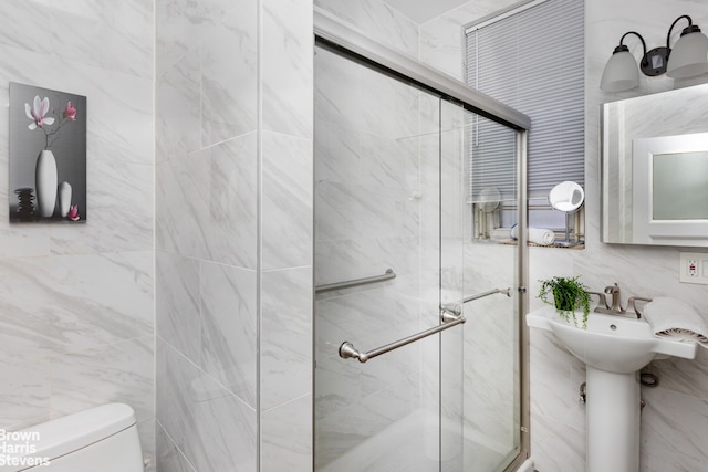 full bathroom with toilet, a stall shower, and tile walls