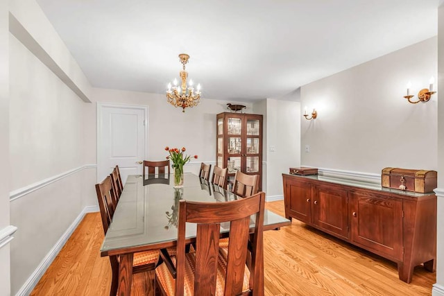 dining area with an inviting chandelier and light hardwood / wood-style floors