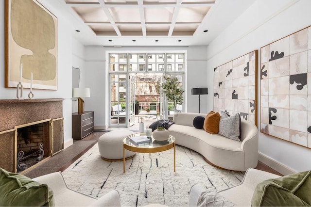 living room with beamed ceiling, a high end fireplace, coffered ceiling, and a high ceiling