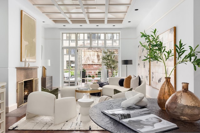 living room featuring beam ceiling, a high ceiling, a fireplace, and coffered ceiling