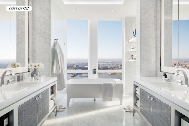 bathroom featuring a freestanding tub, two vanities, and floor to ceiling windows