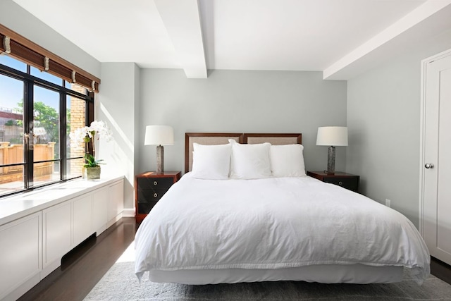 bedroom with multiple windows, dark hardwood / wood-style flooring, and beam ceiling