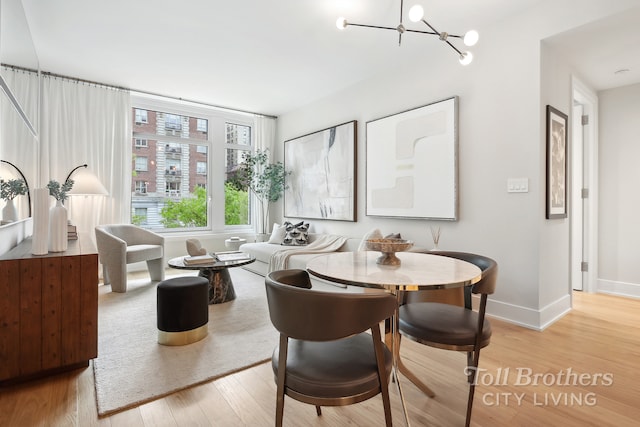 218 W 103rd St Unit 4B, New York City, NY 10025 - dining area with a notable chandelier, wood finished floors, and baseboards
