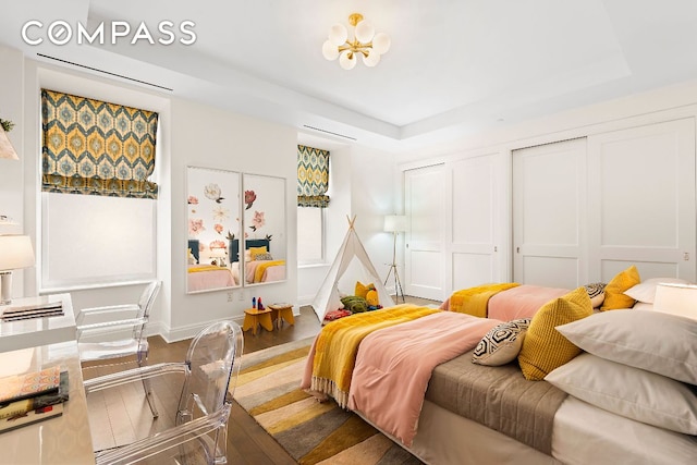 bedroom with hardwood / wood-style flooring and a raised ceiling