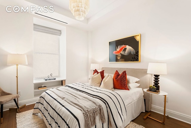 bedroom featuring an inviting chandelier and dark wood-type flooring