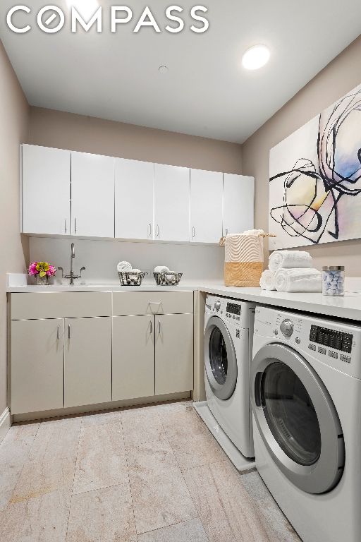 laundry room with cabinets, sink, and washing machine and clothes dryer