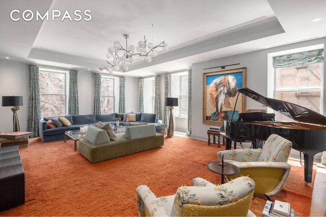 living room with crown molding, carpet floors, a chandelier, and a tray ceiling