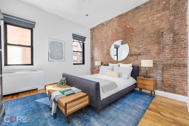 400 W 23rd St Unit 3Lk, New York City, NY 10011 - bedroom featuring brick wall, wood finished floors, and baseboards