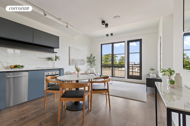 dining room with track lighting and dark hardwood / wood-style flooring