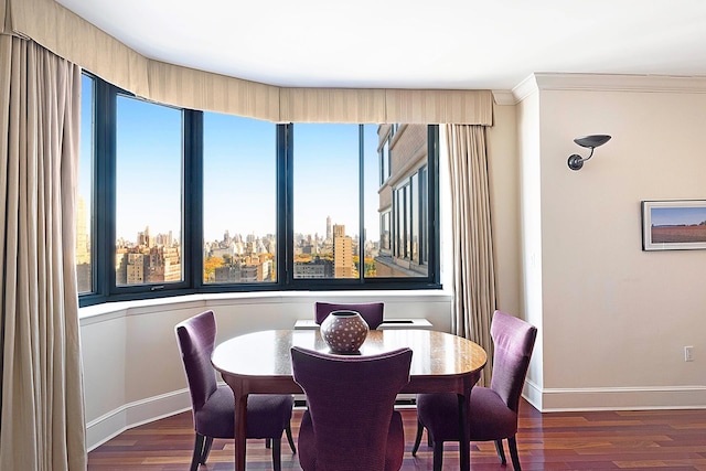 dining area featuring a view of city, baseboards, wood finished floors, and ornamental molding