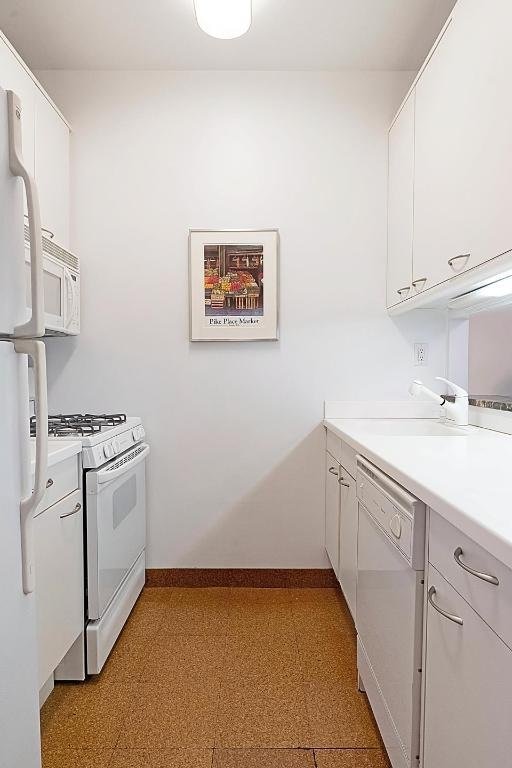 kitchen featuring white appliances and white cabinets