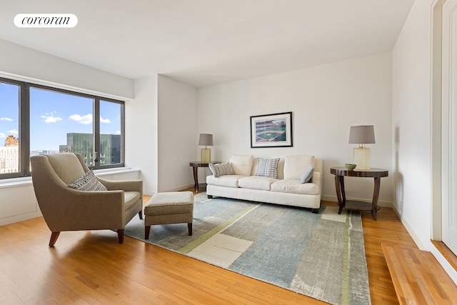 living room with a city view, wood finished floors, visible vents, and baseboards