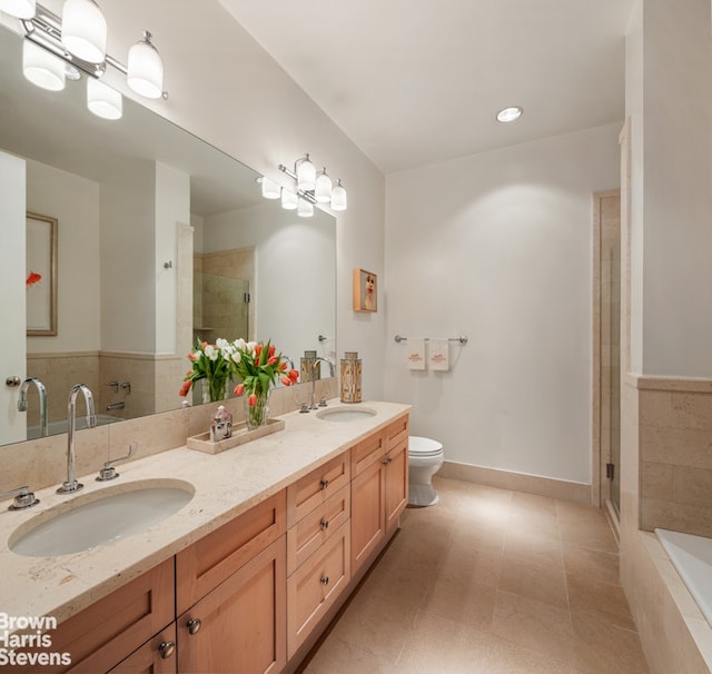 bathroom featuring a sink, toilet, a stall shower, and double vanity