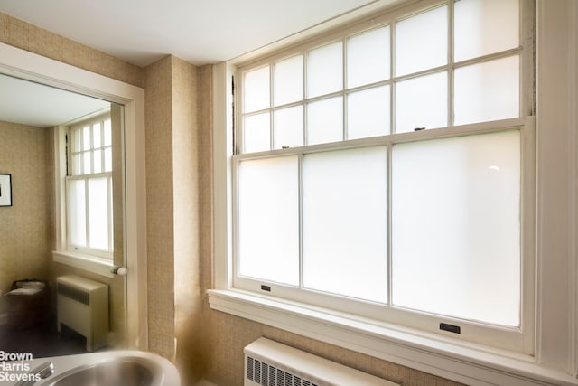 interior space featuring wallpapered walls, a sink, and radiator