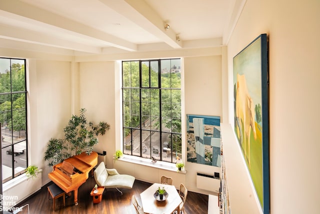 living area with wood finished floors and beam ceiling