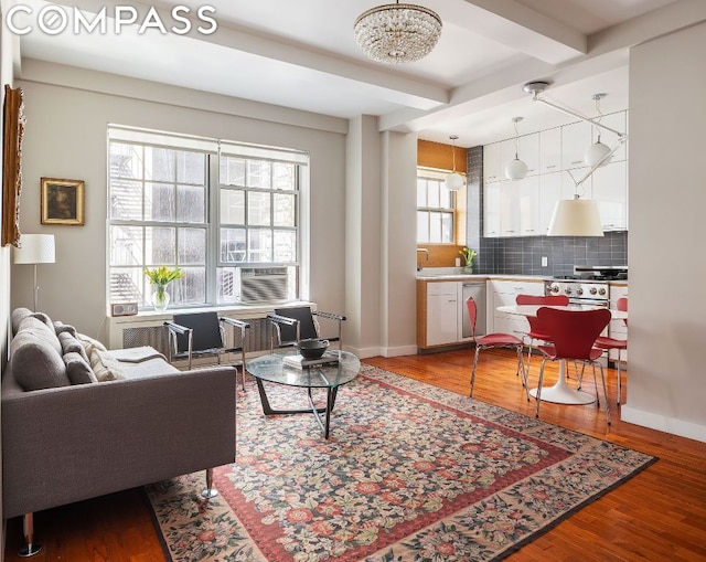 living room featuring a chandelier, hardwood / wood-style flooring, and beamed ceiling