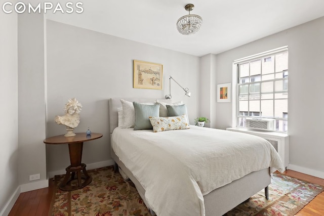 bedroom with cooling unit and hardwood / wood-style flooring