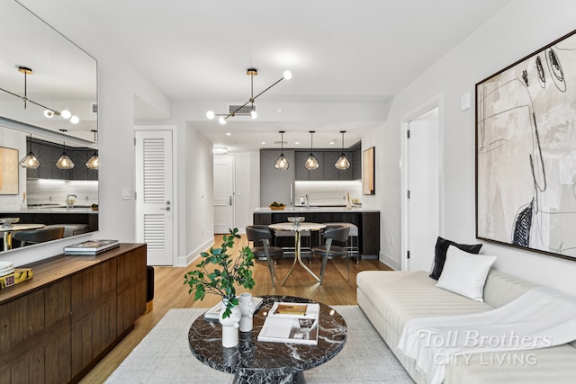 living room with light hardwood / wood-style flooring and sink