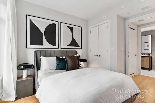 bedroom with light hardwood / wood-style floors and a closet