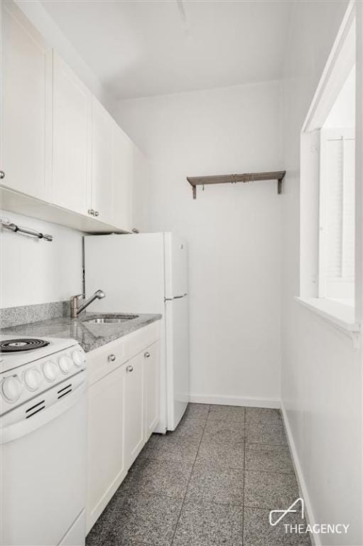 kitchen featuring sink, white cabinets, light stone counters, and white range with electric cooktop