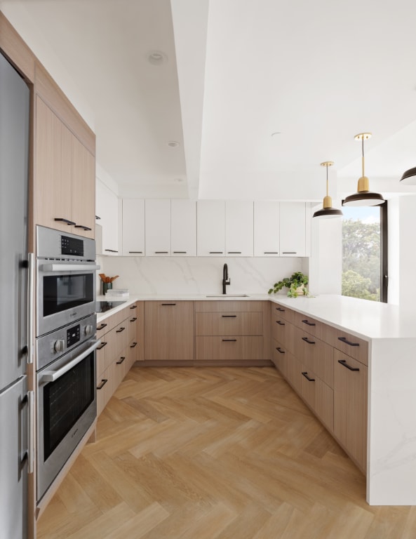 kitchen featuring sink, hanging light fixtures, light brown cabinets, kitchen peninsula, and light parquet flooring