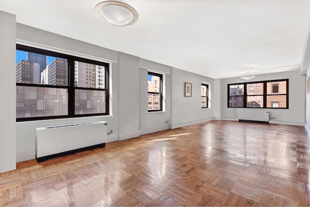 interior space with baseboards, plenty of natural light, and radiator