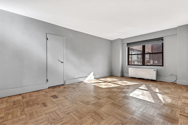 empty room with baseboards and radiator heating unit