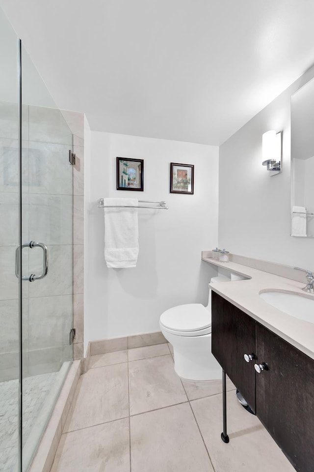 bathroom featuring a shower stall, baseboards, toilet, tile patterned floors, and vanity